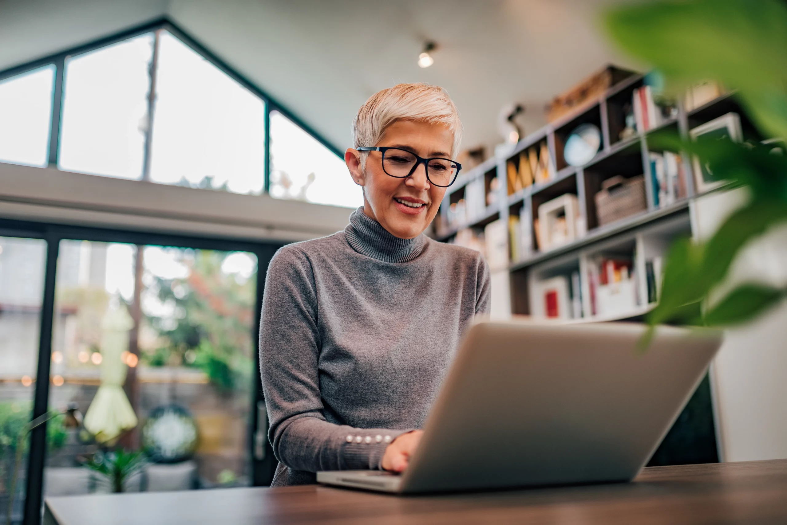 AdobeStock_69979349 En senior som ler med datorn framför